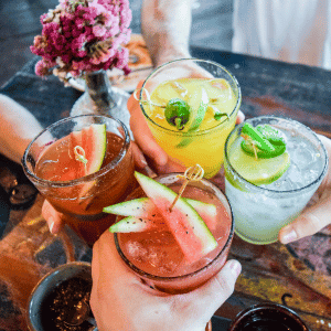 Arcana Durham four friends toasting with cocktails