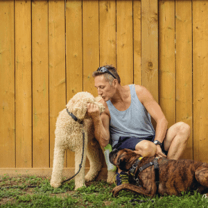 dog walker from Bull City Pet Care playing with two dogs in Durham, NC